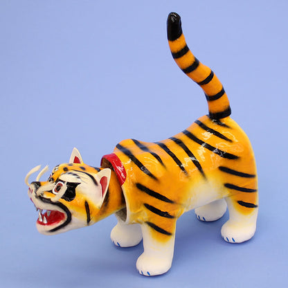 Un tigre en papier mâché décoré d'une poupée de mai, un petit tigre