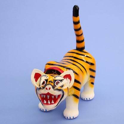 Un tigre en papier mâché décoré d'une poupée de mai, un petit tigre